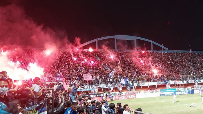 Suporter Persib Bandung menyalakan flare seusai laga melawan PSS Sleman di Stadion Maguwoharjo, Sleman, Jumat (19/8/2022).