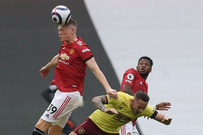 Scott McTominay (kiri) dan Fred (kanan) berduel dengan Josh Brownhll dalam laga Liga Inggris Manchester United vs Burnley di Old Trafford (18/4/2021).