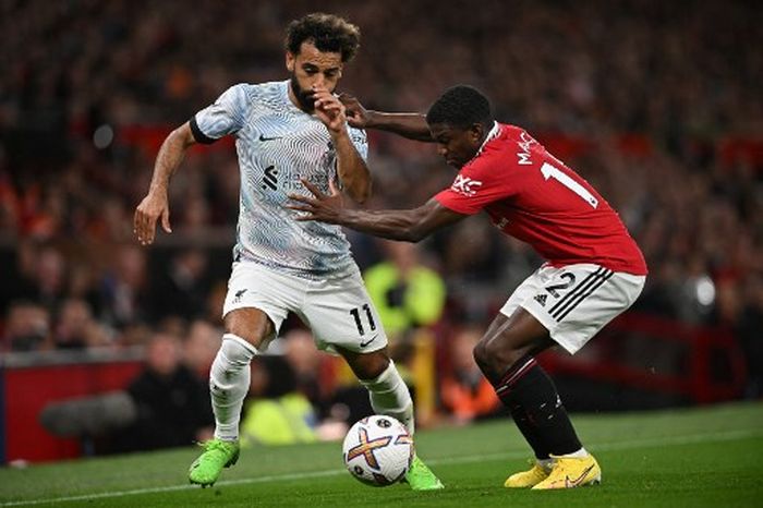 Mohamed Salah (kiri) dikawal ketat Tyrell Malacia dalam duel Manchester United vs Liverpool pada lanjutan Liga Inggris di Old Trafford (22/8/2022).