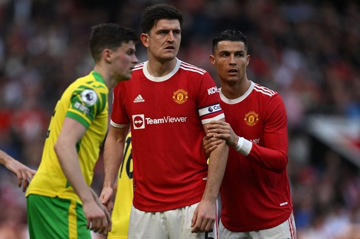 Cristiano Ronaldo memegang lengan Harry Maguire dalam laga Manchester United vs Norwich City di Old Trafford, Manchester (16/4/2022).