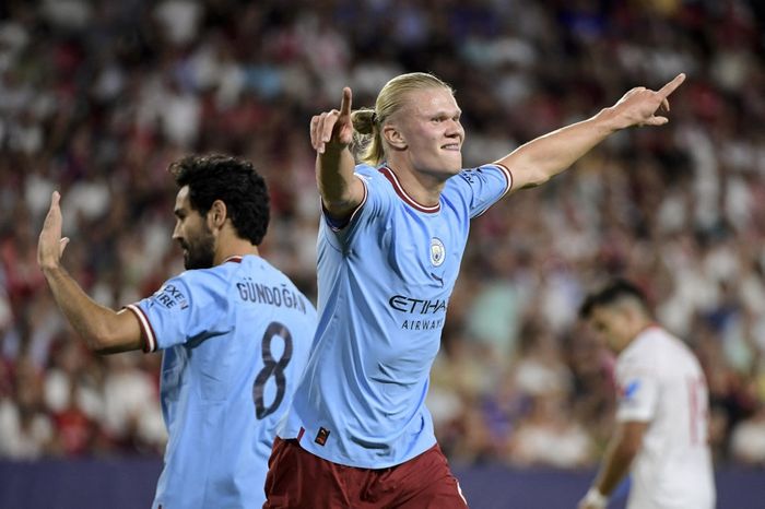 Erling Haaland melakukan selebrasi usai mencetak gol ketiga bagi Manchester City dalam kemenangan atas Sevilla pada laga pekan pertama Liga Champions di Stadion Ramon Sanchez Pizjuan, Selasa (6/9/2022).