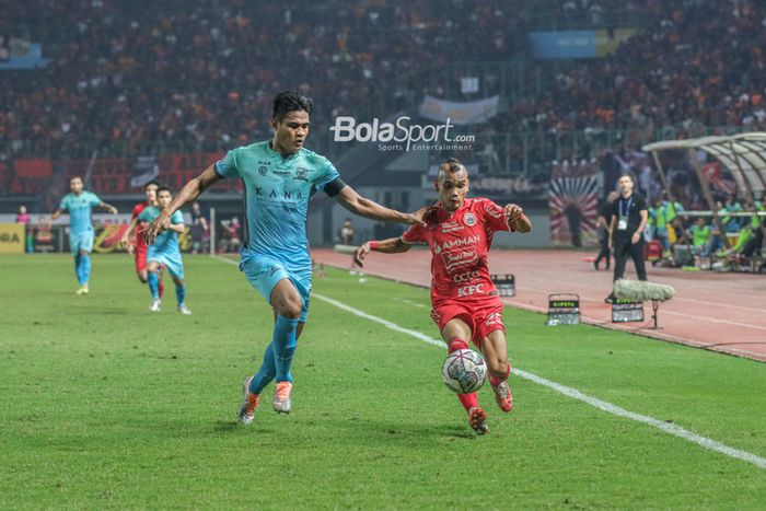 Pemain Persija Jakarta, Riko Simanjuntak (kanan), sedang menguasai bola dan dibayangi bek Madura United bernama Fachruddin Aryanto (kiri) dalam laga pekan ke-10 Liga 1 2022 di Stadion Patriot Candrabhaga, Bekasi, Jawa Barat, 17 September 2022.