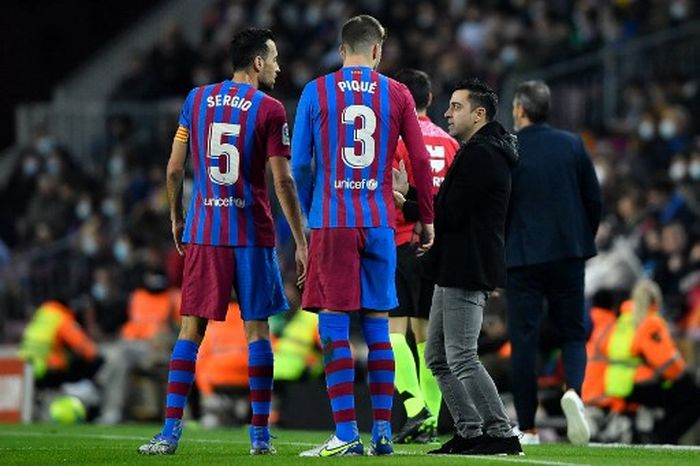 Xavi berbicara dengan Sergio Busquets dan Gerard Pique dalam laga Barcelona vs Espanyol di Camp Nou (20/11/2021).