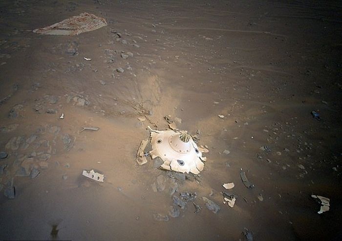 Helikopter Ingenuity mengambil gambar peralatan pendaratan yang digunakan selama kedatangannya dengan Perseverance. Gambar ini adalah parasut dan cangkang berbentuk kerucut yang melindungi rover di luar angkasa.