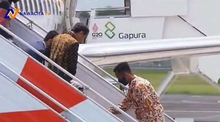 Paspampres menolong Iriana Jokowi yang terjatuh di anak tangga pesawat. 