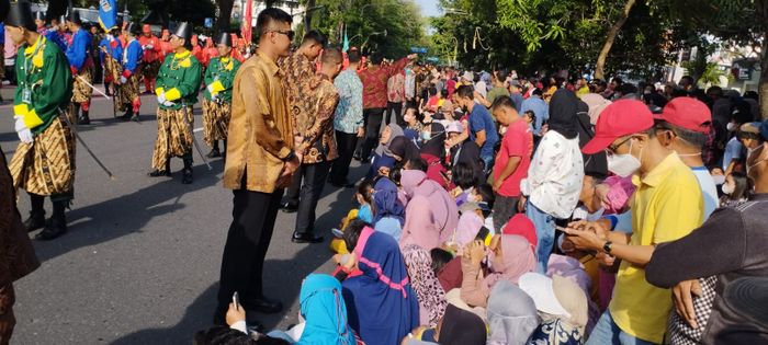 Warga Solo tertib mengikuti perintah paspampres untuk duduk jelang kirab pernikahan Kaesang dan Erina.