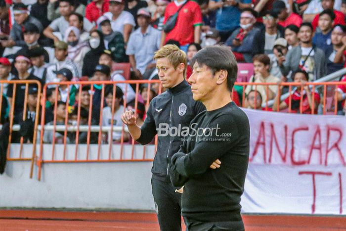 Manajer Timnas Kamboja, Keisuke Honda (kiri) dan Pelatih Timnas Indonesia, Shin Tae-yong (kanan), sedang memantau timnya bertanding dalam laga pekan pertama Grup A Piala AFF 2022 di Stadion Gelora Bung Karno, Senayan, Jakarta, 23 Desember 2022.