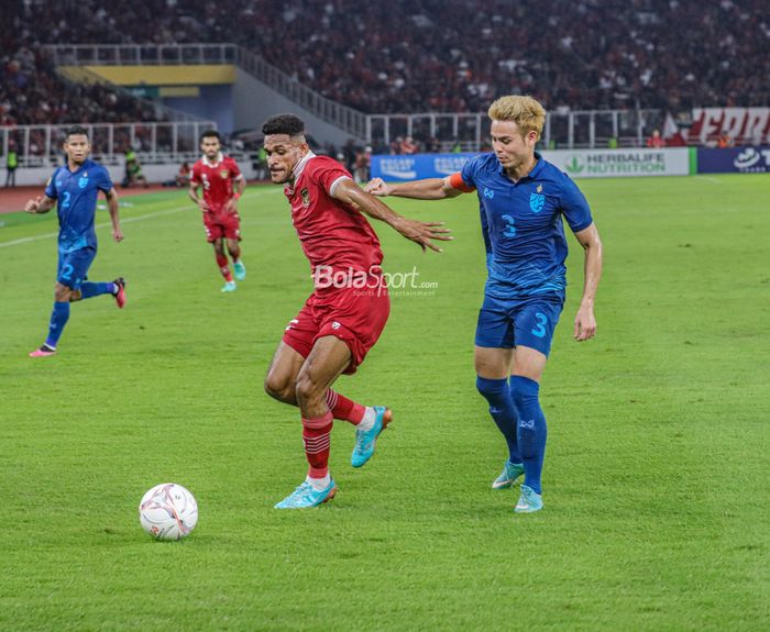 Gelandang timnas Indonesia, Ricky Kambuaya (kiri), sedang menguasai bola dan dibayangi pemain timnas Thailand bernama Theerathon Bunmathan (kanan) dalam laga Piala AFF 2022 di Stadion Utama Gelora Bung Karno, Senayan, Jakarta, 29 Desember 2022.