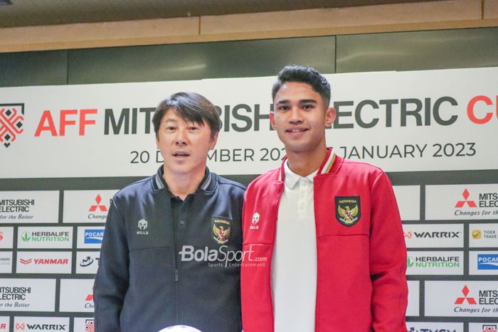 Pelatih Timnas Indonesia Shin Tae-yong dan Marselino Ferdinan berfoto bersama seusai konferensi pers jelang semifinal leg pertama Piala AFF 2022 melawan Vietnam. 