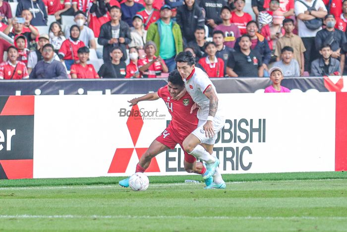 Bek sayap kanan timnas Indonesia, Asnawi Mangkualam Bahar (kiri), tampak sedang berebut bola dengan pemain timnas Vietnam bernama Doan Van Hau (kanan) saat berlaga pada leg pertama semifinal Piala AFF 2022 di Stadion Gelora Bung Karno, Senayan, Jakarta, 6 Desember 2023.