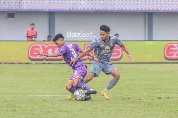 Gelandang Persebaya Surabaya, Marselino Ferdinan (kanan), sedang berebut bola dengan pemain Persita Tangerang bernama Arif Setiawan (kiri) dalam laga pekan ke-18 Liga 1 2022 di Stadion Indomilk Arena, Tangerang, Banteng, Rabu (18/1/2023).