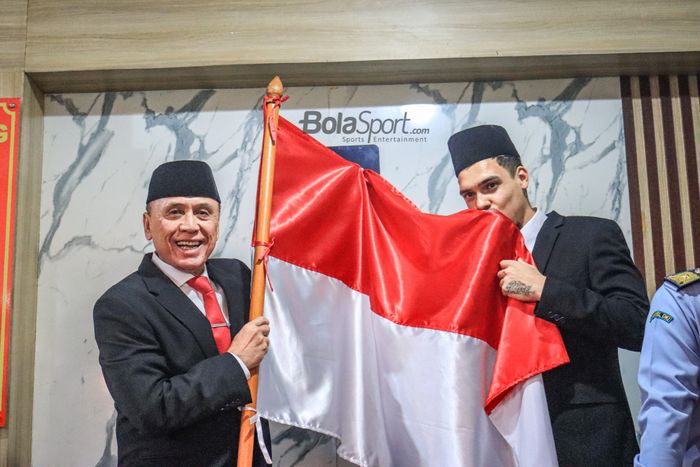 Pemain naturalisasi timnas Indonesia, Shayne Pattynama (kanan), sedang mencium bendera Merah Putih dan ditemani Mochamad Iriawan (kiri) selaku Ketua Umum PSSI di Kemenkumham Wilayah DKI Jakarta, Cakung, Jakarta Selatan, 24 Januari 2023.