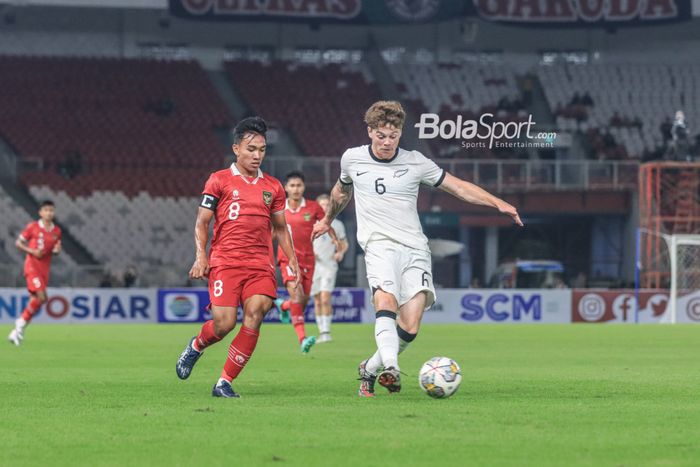 Pemain timnas U-20 Selandia Baru, Fin Ngahina Roa Conhchie (kanan), sedang mengoper bola dan dibayangi gelandang timnas U-20 Indonesia bernama Arkhan Fikri (kiri) dalam laga turnamen Mini Internasional di Stadion Gelora Bung Karno, Senayan, Jakarta, Minggu (19/2/2023) malam.