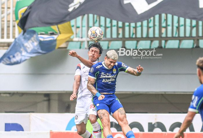 Bek sayap kiri Arema FC, Johan Alfarizie (kiri), sedang berduel udara menyundul bola dengan striker asing Persib Bandung bernama Ciro Alves (kanan) dalam laga pekan ke-26 Liga 1 2022 di Stadion Pakansari, Bogor, Jawa Barat, Kamis (23/2/2023).