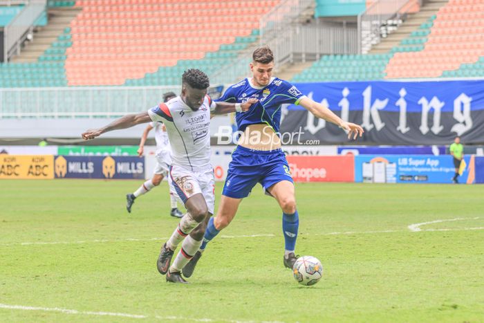 Striker asing Arema FC, Abel Issa Camara (kiri), sedang menguasai bola dan berusaha direbut bek berpaspor luar negeri Persib Bandung bernama Nick Kuipers (kanan) dalam laga pekan ke-26 Liga 1 2022 di Stadion Pakansari, Bogor, Jawa Barat, Kamis (23/2/2023).