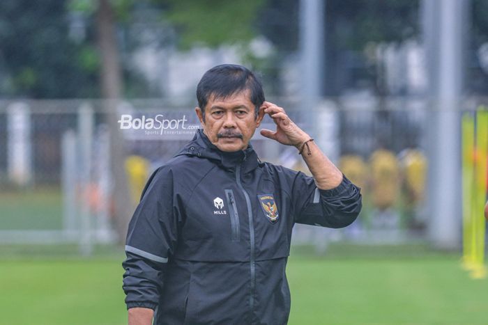Pelatih timnas U-22 Indonesia, Indra Sjafri, sedang memegangi kepalanya sebagai tanda memikirkan strategi saat memantau timnya berlatih di Lapangan B, Senayan, Jakarta, Kamis (2/3/2023).