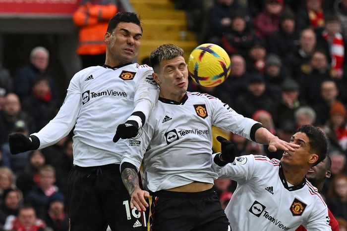 Tiga pemain Manchester United, Casemiro, Lisandro Martinez, dan Raphael Varane berusaha mengincar bola dalam laga Liga Inggris kontra Liverpool di Stadion Anfield, Minggu (5/3/2023).