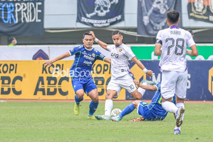 Gelandang Persik Kediri, Renan Silva (tengah), sedang menguasai bola dan dibayangi pemain Persib Bandung bernama Dedi Kusnandar (kiri) dalam laga pekan ke-29 Liga 1 2022 di Stadion Pakansari, Bogor, Jawa Barat, Rabu (8/3/2023).