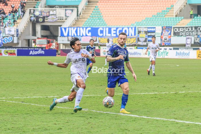 Gelandang Persib Bandung, Marc Klok (kanan), sedang menguasai bola dan dibayangi pemain Persik Kediri bernama Yusuf Meilana Fuad Burhani (kiri) dalam laga pekan ke-29 Liga 1 2022 di Stadion Pakansari, Bogor, Jawa Barat, Rabu (8/3/2023).