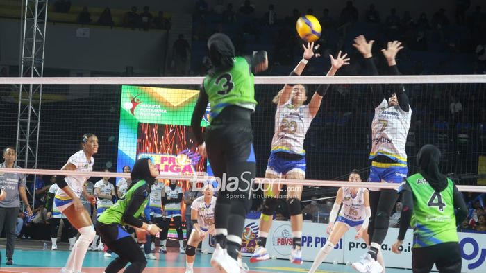 Pemain Bandung bjb Tandamata, Shella Bernadetha (#20) dan Nandita Ayu Salsabilla (#7), berupaya memblok spike keras opposite hitter andalan Jakarta Pertamina Fastron, Megawati Hangestri Pertiwi.