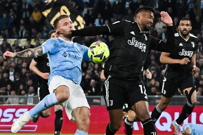 Ciro Immobile (kiri) berduel dengan Alex Sandro dalam partai Lazio vs Juventus pada lanjutan Liga Italia di Olimpico, Roma (8/4/2023).