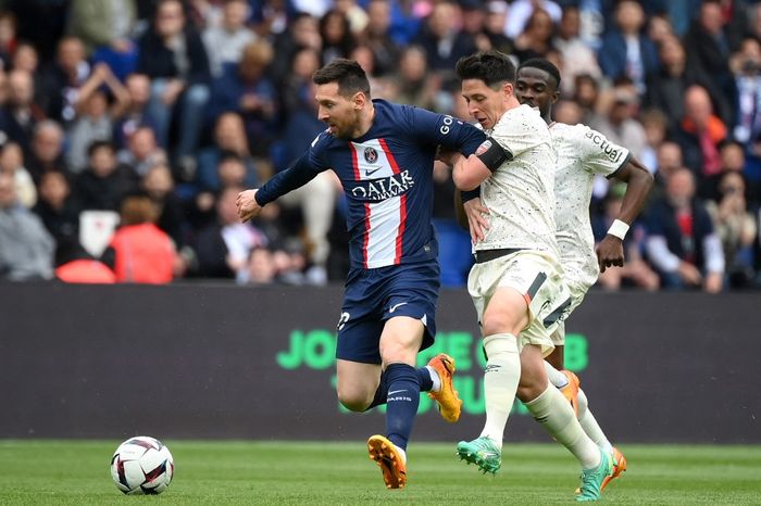 Penyerang Paris Saint-Germain, Lionel Messi (kiri), berebut bola dengan gelandang Prancis Laurent Abergel (kanan) selama pertandingan sepak bola Liga Prancis 2022-2023  antara Paris Saint-Germain (PSG) dan FC Lorient di Stadion Parc des Princes di Paris pada 30 April 2023