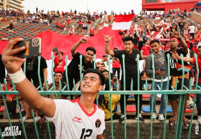 Bek Timnas U-22 Indonesia Pratama Arhan berswafoto dengan suporter seusai menang 3-0 atas Timor Leste dalam SEA Games 2023 di Kamboja.