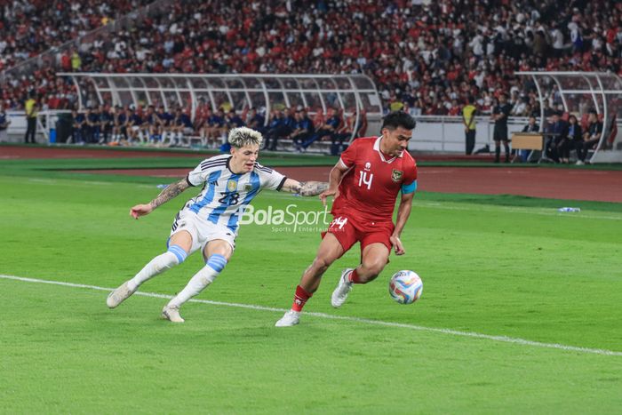 Bek sayap kanan timnas Indonesia, Asnawi Mangkualam Bahar (kanan), sedang mengecoh pemain timnas Argentina bernama Alejandro Garnacho (kiri) saat bertanding di Stadion Utama Gelora Bung Karno, Senayan, Jakarta, Senin (19/6/2023) malam.