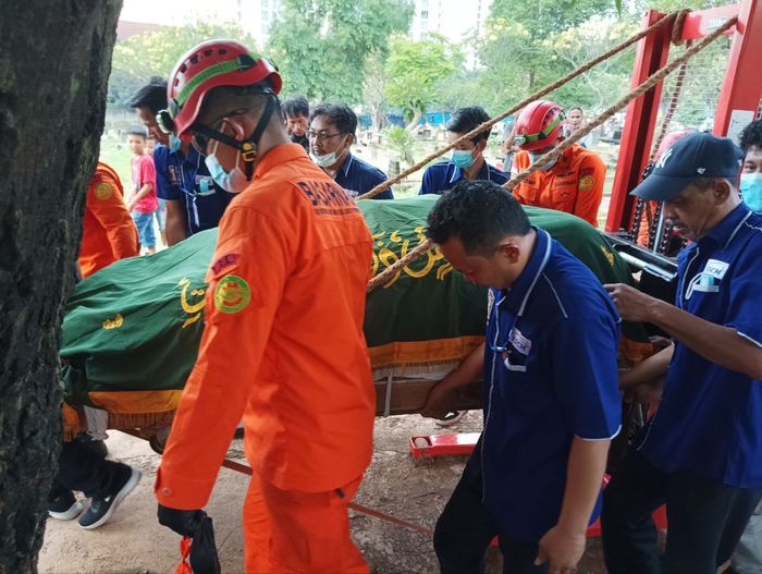 Sekitar 15 orang dari tim Basarnas dan dari tim pemulasaran jenazah RSCM membantu mendorong forklift sembari memegangi jenazah Fajri yang tetutup kain hijau.