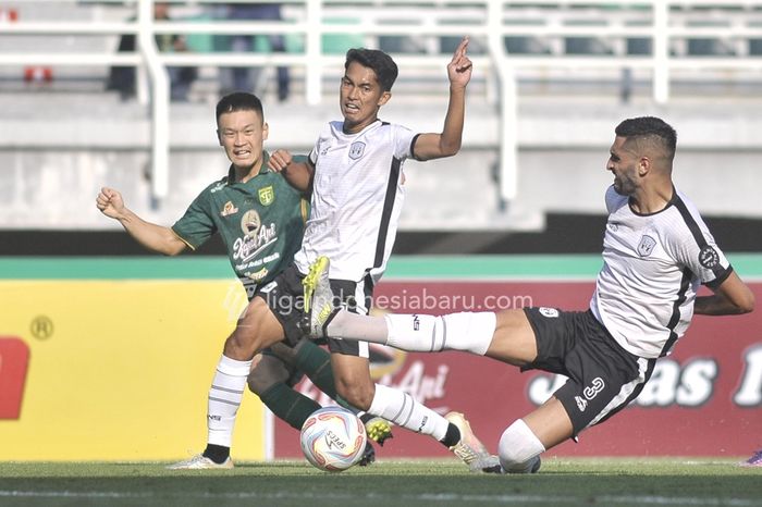 Pemain Persebaya Surabaya, Sho Yamamoto, berduel dengan dua pemain RANS Nusantara FC pada pekan keempat Liga 1 2023/2024.