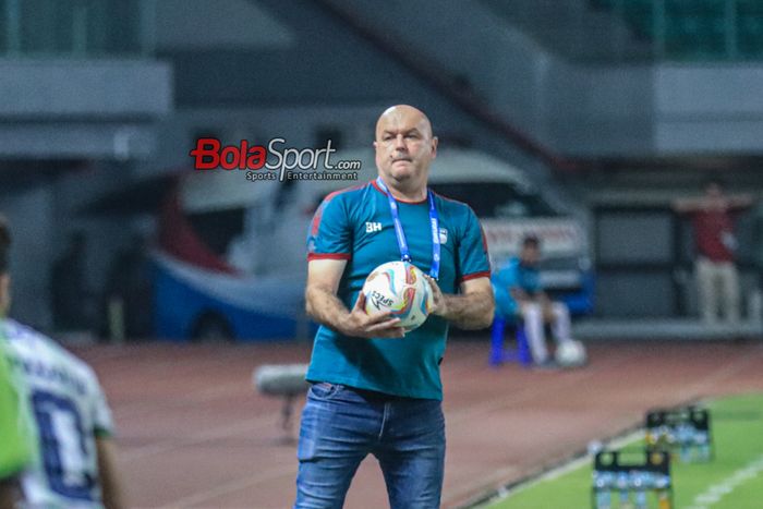 Pelatih Persib Bandung, Bojan Hodak, sempat memegangi bola saat memantau para pemainnya bertanding di Stadion Patriot Candrabhaga, Bekasi, Jawa Barat, Sabtu (23/9/2023).