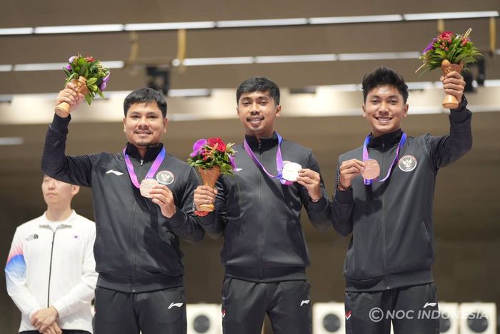 Regu petembak Indonesia: Irfandi Julio, Muhammad Sejahtera Dwi Putra, dan Muhammad Badri Akbar berdiri di podium  usai meraih medali perunggu Asian Games 2022 dari nomor 10m beregu putra di Fuyang Yinhu Sports Centre, Hangzhou, China, 25 September 2023