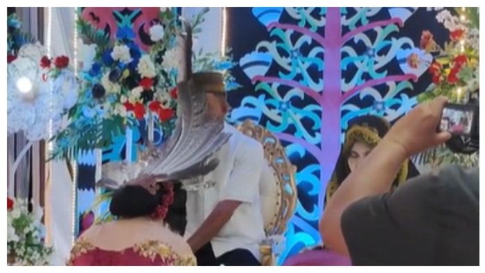 Bulu mahkota pengantin tutupi wajah si bapak