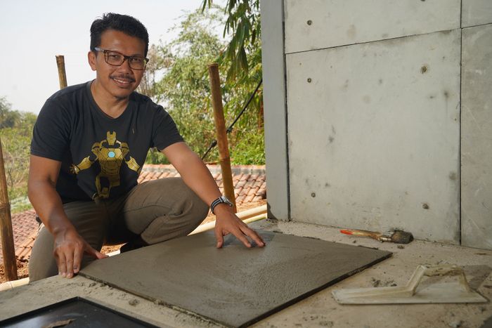 Muhammad Arief Irfan sedang menunjukkan proses pembuatan panel-panel komposit yang sebagian materialnya terbuat dari limbah popok.