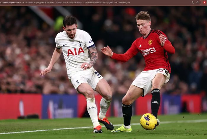 Scott McTominay (merah) dan Pierre-Emile Hojbjerg (putih) berduel dalam laga Manchester United vs Tottenham Hotspur di Stadion Old Trafford, Minggu (14/1/2024).