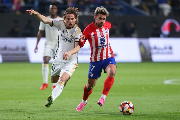 Luka Modric (kiri) berduel dengan Antoine Griezmann dalam derbi ibu kota Spanyol antara Real Madrid vs Atletico Madrid pada pentas Supercopa de Espana di Riyadh (10/1/2024).