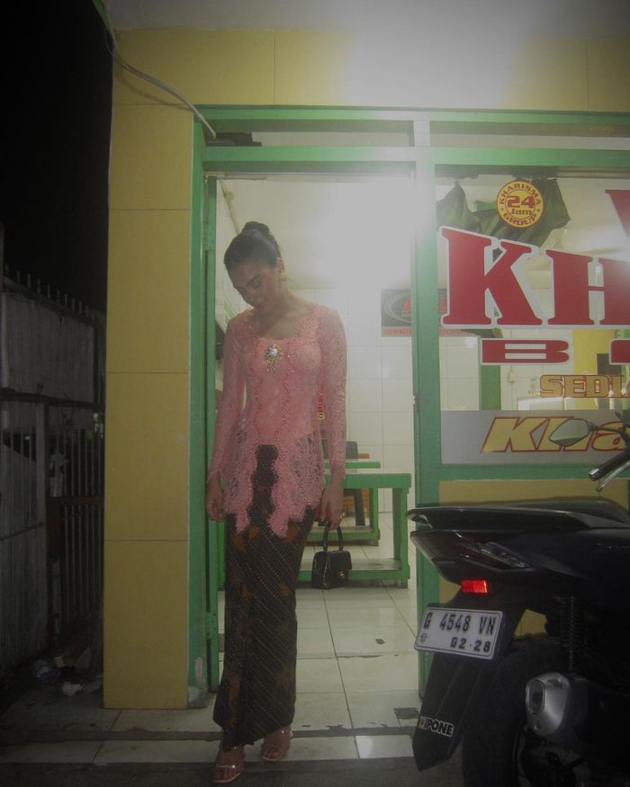 Eva Celia berfoto di depan warteg saat kenakan kebaya kutu baru.