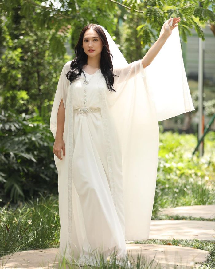 Gaya Laura Moane kenakan kaftan serba putih.