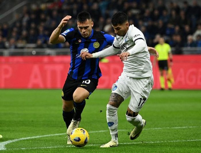 Penyerang Inter Milan, Lautaro Martinez (kiri), berduel dengan bek Napoli, Mathias Olivera, di pekan ke-29 Liga Italia, Minggu (17/3/2024) di Stadion Giuseppe Meazza.