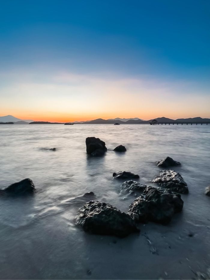 Contoh penggunaan Live Photos pada iPhone untuk memotret long exposure foto lanskap pantai berombak. Fitur canggih ini bisa membuat fotografi ponsel tidak kalah bagus dari kamera biasa.