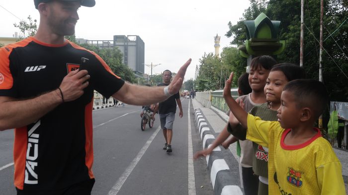 Kru balap KTM sedang Tos dengan anak-anak Lombok dalam acara parade MXGP NTB 2024