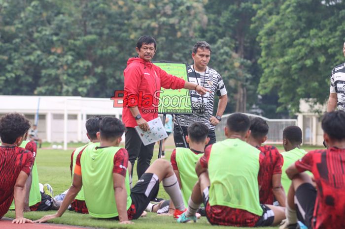 Pelatih timnas U-19 Indonesia, Indra Sjafri (kiri) dan asistennya bernama Bima Sakti (kanan) sedang memantau para pemainnya berlatih di Stadion Madya, Senayan, Jakarta, Senin (1/7/2024).