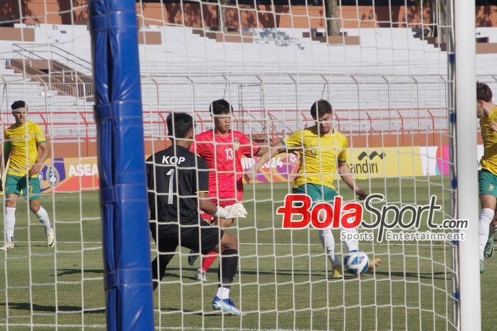 Pemain Australia Arion Sulemani (kanan) sedang menguasai bola di depan gawang Laos U-19 di hadang oleh Kiper Laos U-19 Kop Lokphathip di Stadion Gelora 10 November, Surabaya, Jawa Timur, Kamis (18/7/2024) sore. 