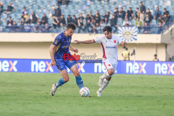 Mateo Kocijan (kiri) sedang menguasai bola dan dibayangi Muhammad Arfan (kanan) dalam laga pembuka Piala Presiden 2024 antara Persib Bandung versus PSM Makassar di Stadion Si Jalak Harupat, Bandung, Jawa Barat, Jumat (19/7/2024).