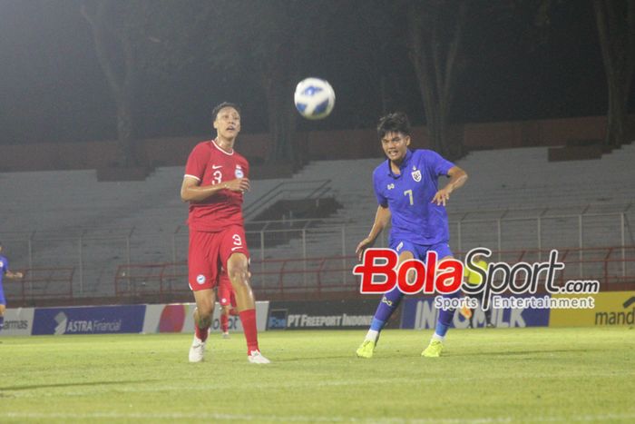 Tendangan Penyerang Singapura U-19 Thanawut Phochai (kanan) masih jauh dari gawang pemain Singapura M. Ikram handir membayangi di Stadion Gelora 10 November, Surabaya, Jawa Timur, Jumat (19/7/2024) malam.