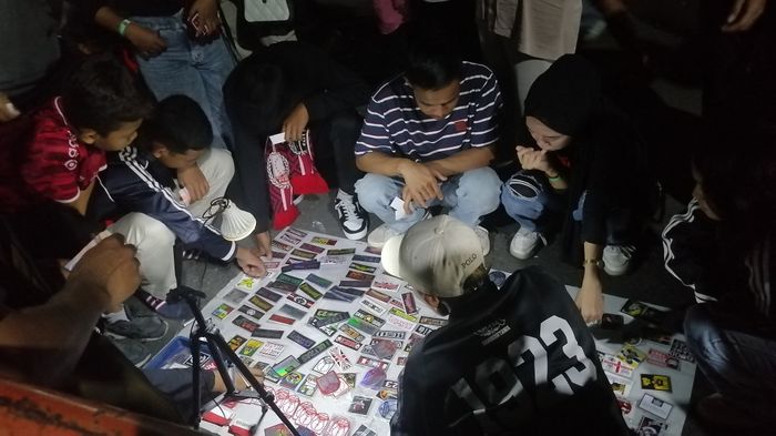 Penjual stiker saat melayani suporter usai laga perebutan tempat ketiga antara Persis Solo vs Persija Jakarta di stand UMKM, Stadion Manahan, Solo, Sabtu (3/8/2024) malam WIB