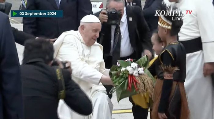 Paus Fransiskus mendapatkan buket bunga dari 2 anak terpilih.