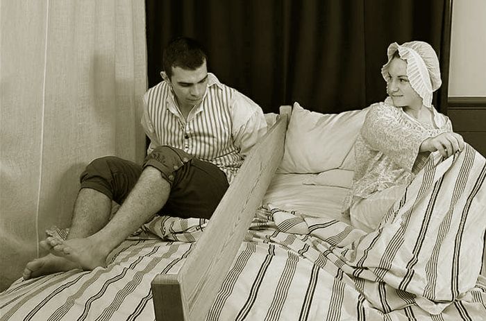 Reka ulang bedboards atau papan pada ranjang yang jadi tradisi di Amerika pada era kolonial sebagai medium penguji kecocokan di antara sepasang kekasih muda jelang pernikahan mereka tanpa saling bersentuhan.