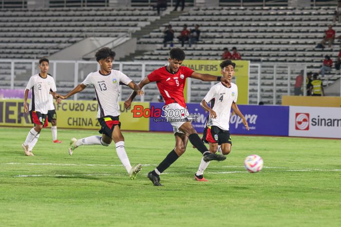 Penyerang timnas U-20 Yaman, Abdulaziz Awadh Masnom (tengah), sedang menendang bola dan dibayangi dua pemain timnas U-20 Timor Leste yakni Emidio Martins Braz (kiri) dan Auro Viera Costa (kanan) dalam laga Kualifikasi Piala Asia U-20 2025 di Stadion Madya, Senayan, Jakarta, Rabu (25/9/2024).