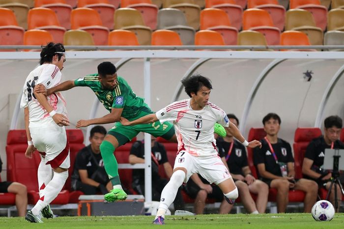 Kaoru Mitoma (kanan) berebut bola dengan Rayan Hamed dalam duel timnas Arab Saudi vs Jepang pada Kualifikasi Piala Dunia 2026 di Jeddah (10/10/2024).